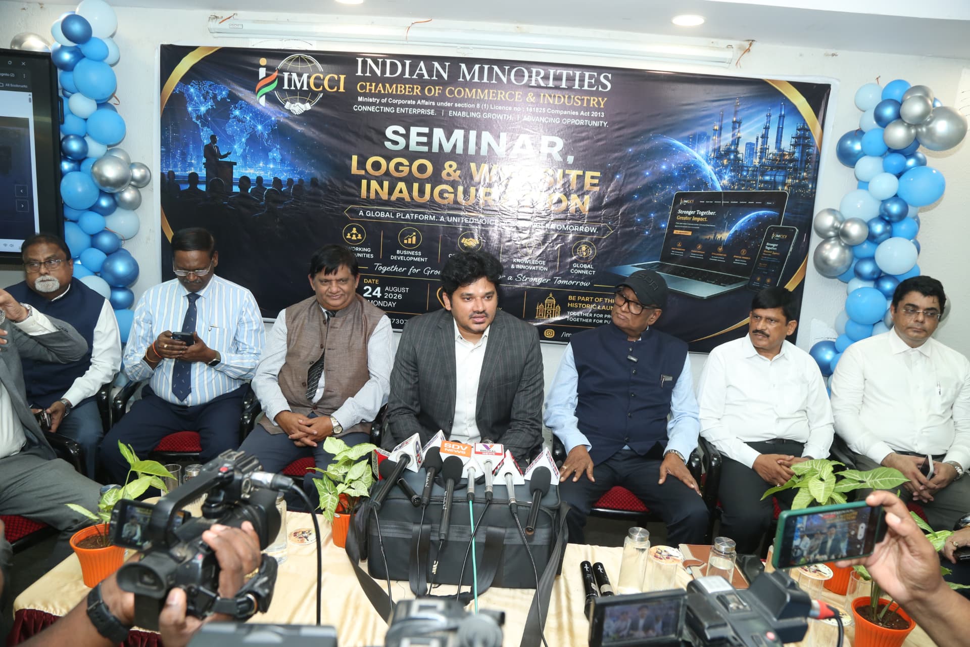 Journalists with microphones and cameras interacting with IMCCI at the launch