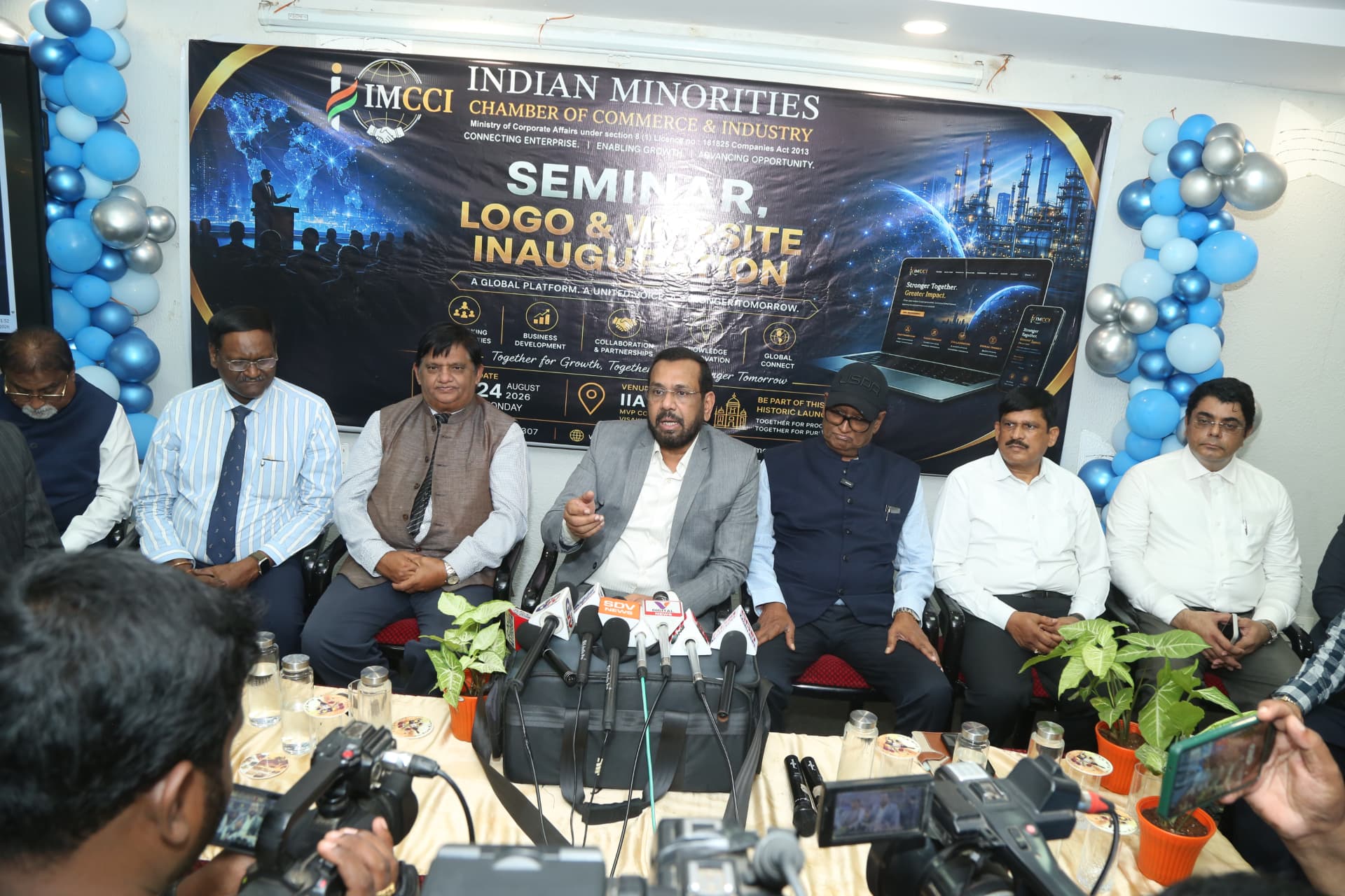 IMCCI representative speaking to journalists with microphones and cameras at the launch